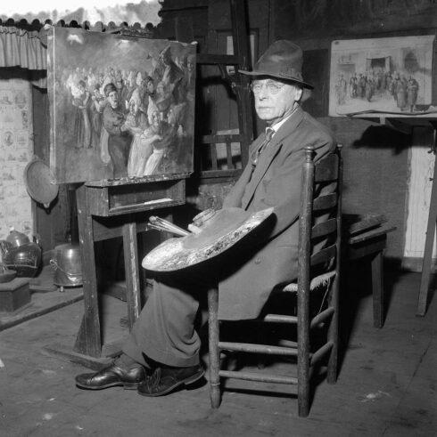 volendamse-kunstschilder-adri-bleys -poserend voor een een volendammer schilderij